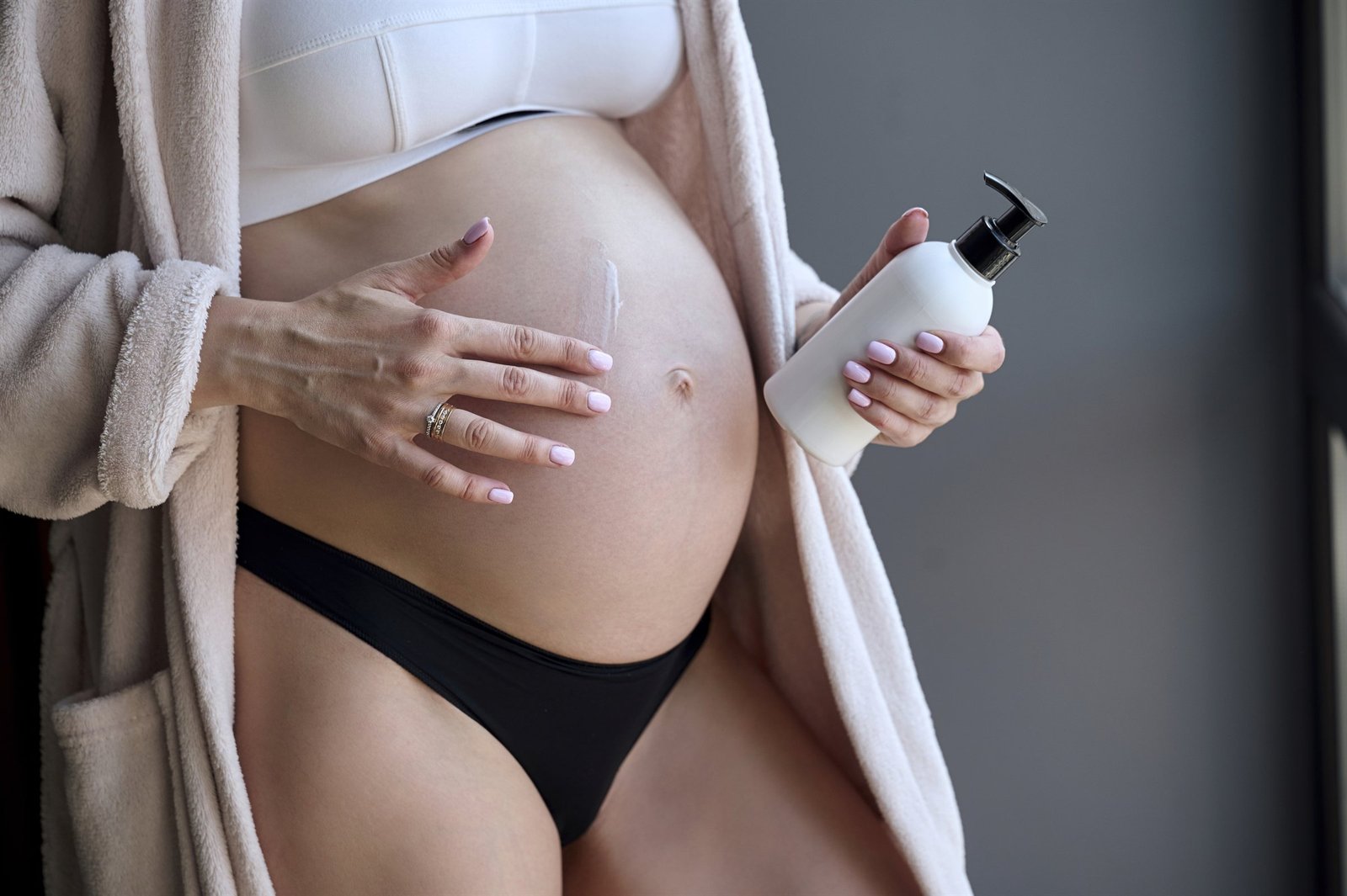 Mujer embarazada aplicando producto Mommy's Love sobre su vientre